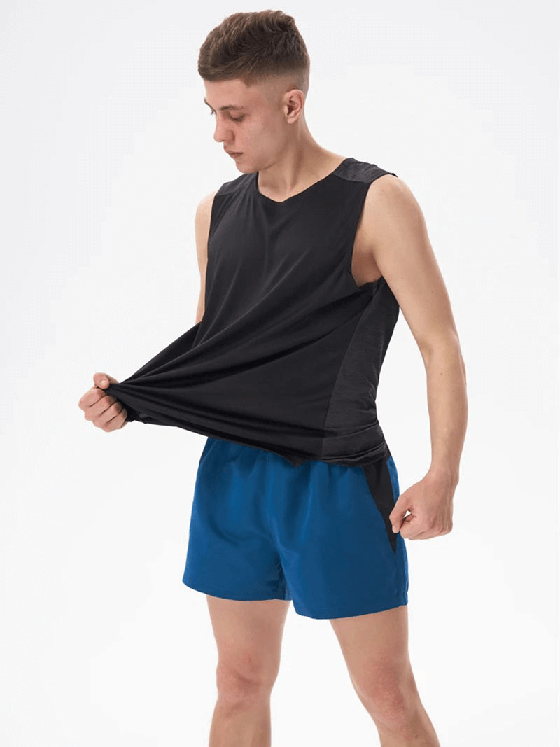 Man wearing Gym Breathable Double Color Tank Top SF1813 in black and blue, showcasing lightweight and breathable polyester design for workouts.